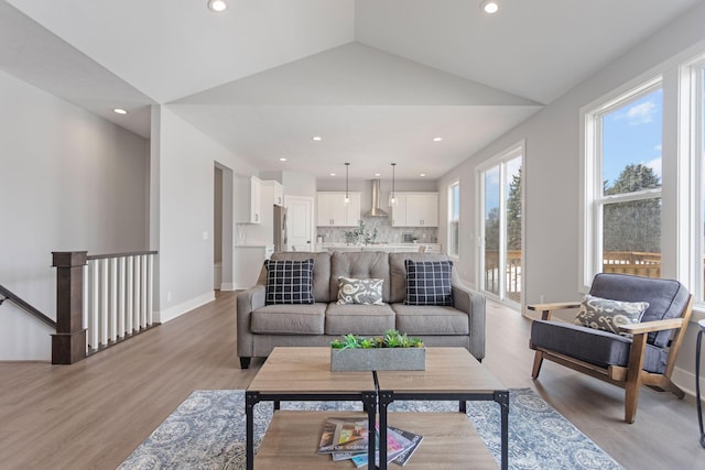 living room with lofted ceiling, light wood-style flooring, baseboards, and recessed lighting