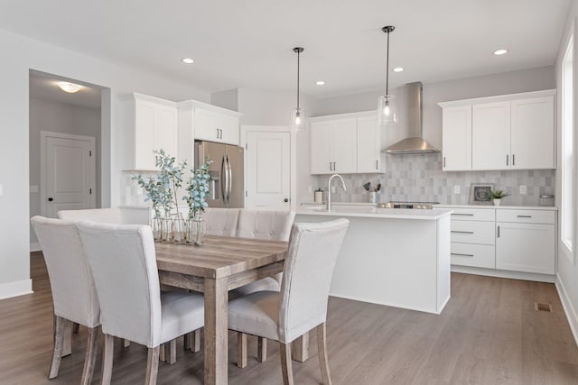 dining space featuring baseboards, visible vents, wood finished floors, and recessed lighting