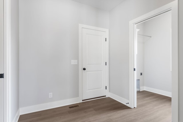 interior space featuring visible vents, baseboards, and wood finished floors