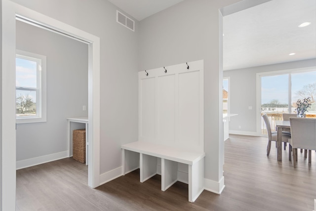 mudroom featuring visible vents, plenty of natural light, baseboards, and wood finished floors