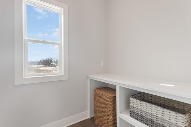 mudroom with dark wood-style floors and baseboards