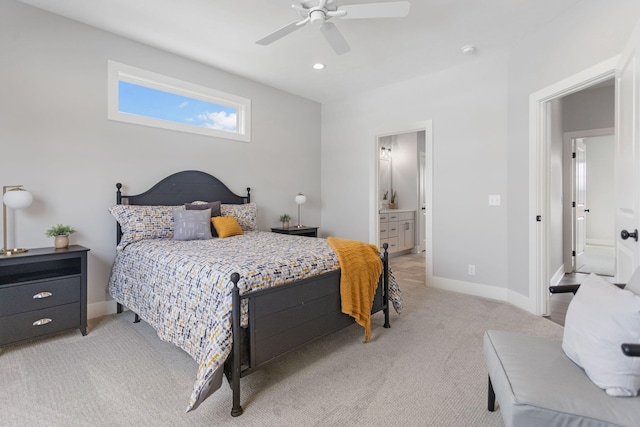 bedroom featuring baseboards, ceiling fan, ensuite bathroom, and light colored carpet