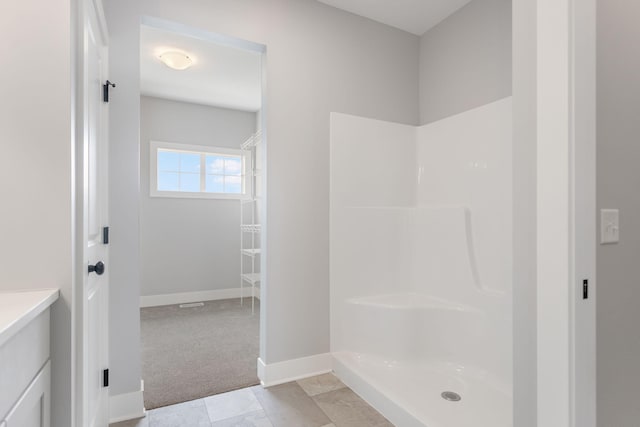 full bathroom featuring vanity, baseboards, and walk in shower