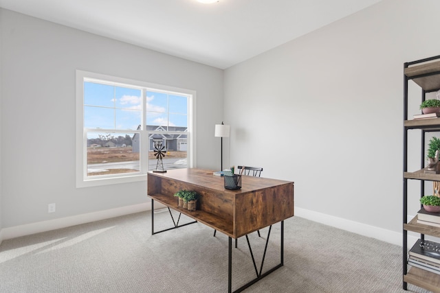 carpeted office space featuring baseboards