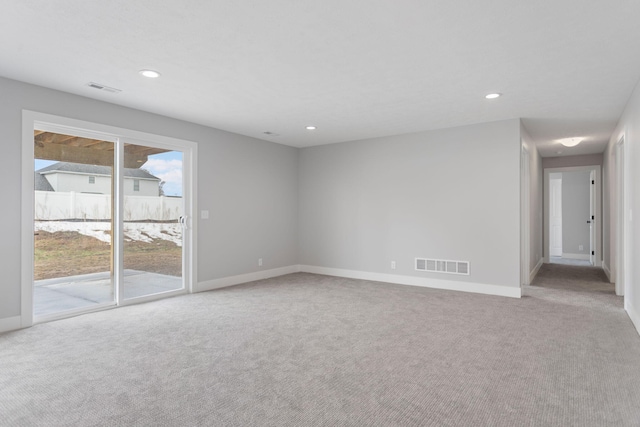 carpeted spare room featuring baseboards, visible vents, and recessed lighting