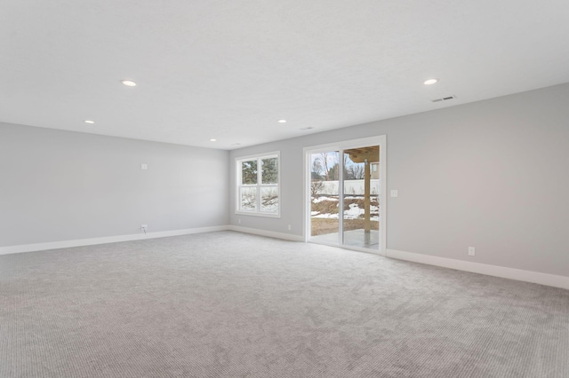 unfurnished room with visible vents, recessed lighting, light colored carpet, and baseboards