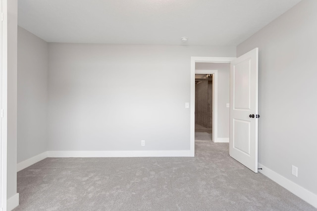 carpeted empty room featuring baseboards