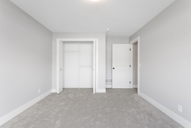 unfurnished bedroom featuring carpet floors, baseboards, and a closet