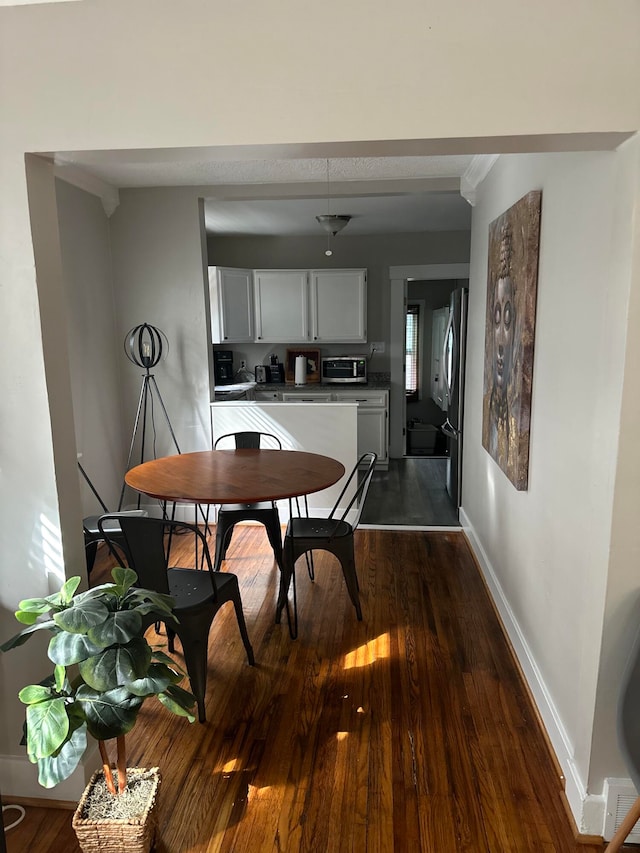 dining space featuring dark wood-type flooring