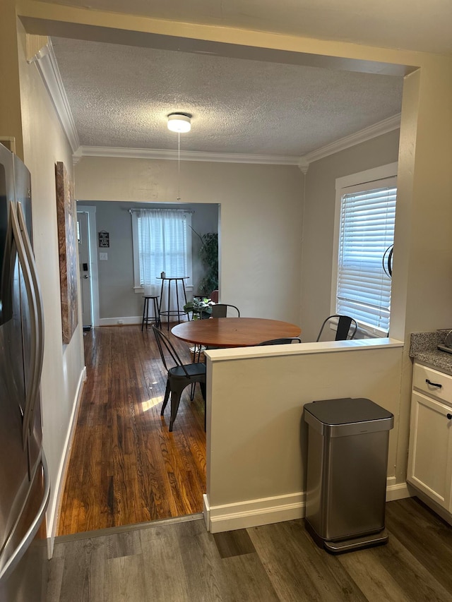 dining area with dark hardwood / wood-style floors, a wealth of natural light, and a textured ceiling