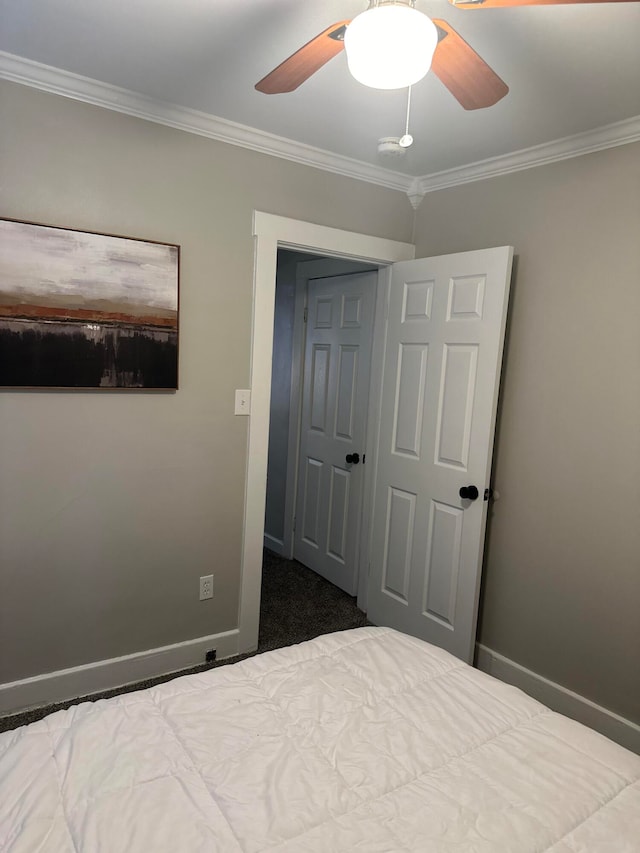 unfurnished bedroom featuring crown molding, ceiling fan, a closet, and carpet flooring