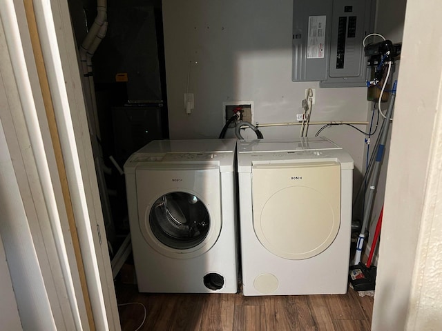 laundry room featuring electric panel, dark wood-type flooring, and washer and dryer