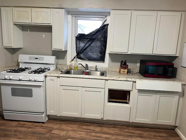 kitchen featuring dark wood-type flooring, white cabinets, sink, and gas range gas stove