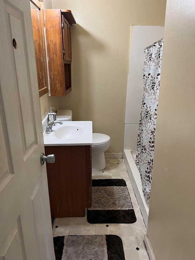 bathroom with walk in shower, tile patterned floors, vanity, and toilet