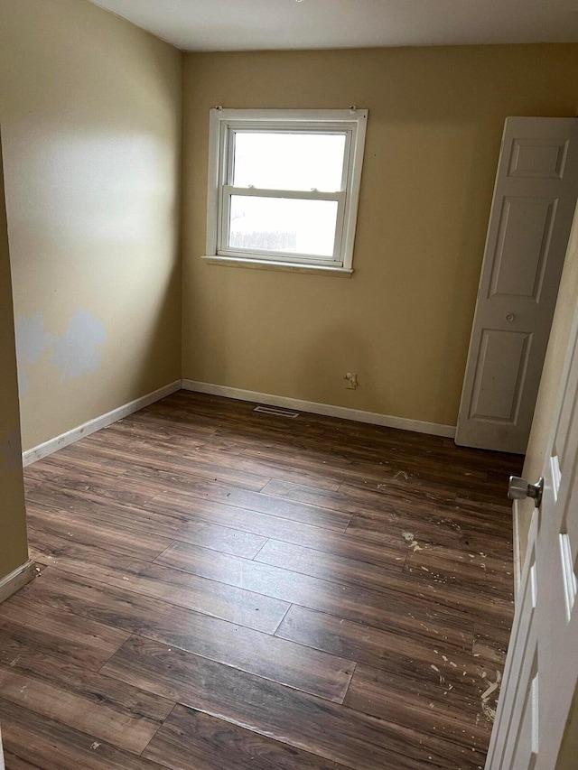 spare room with dark wood-type flooring