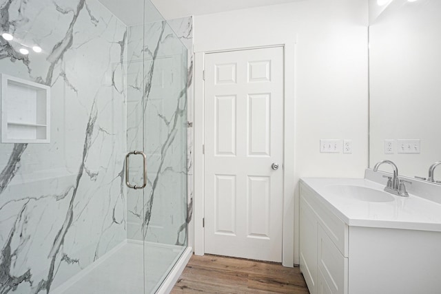 bathroom with walk in shower, wood-type flooring, and vanity