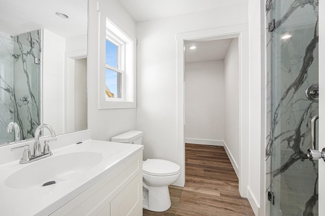 bathroom featuring vanity, hardwood / wood-style floors, a shower with shower door, and toilet