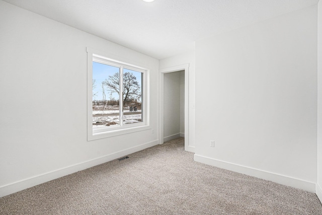 unfurnished room with carpet flooring and a textured ceiling