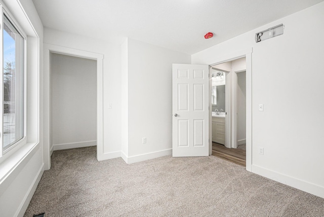 unfurnished bedroom featuring sink and light carpet