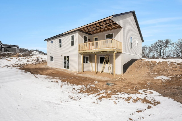 snow covered house featuring a deck