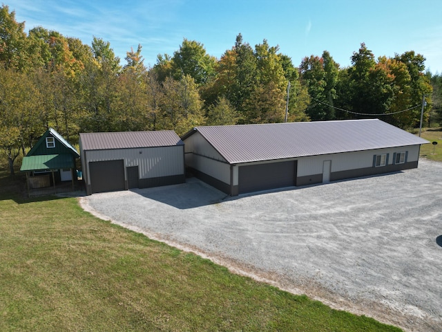 view of front of home with a garage, an outbuilding, and a front lawn