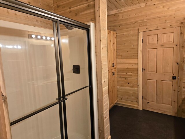 bathroom featuring wooden walls, a shower with door, and wooden ceiling