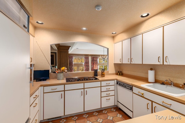 kitchen with white dishwasher, sink, and white cabinets