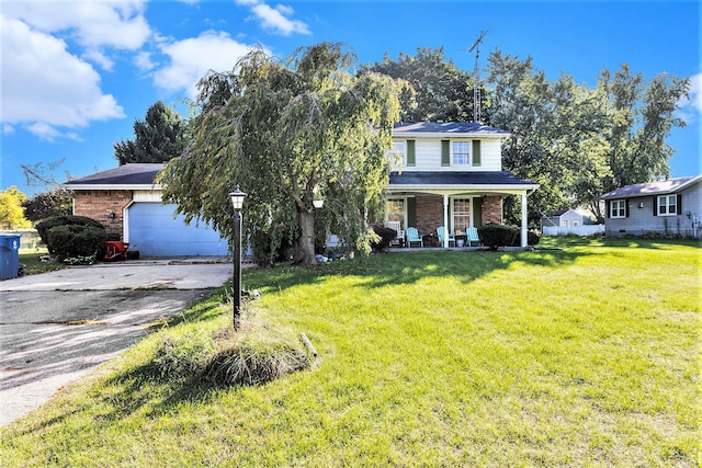 view of front of home with a garage, a front lawn, and covered porch