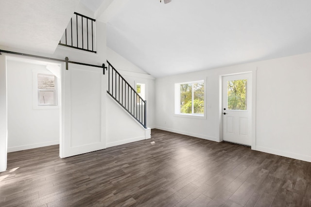 entryway featuring a barn door, vaulted ceiling, and dark hardwood / wood-style floors