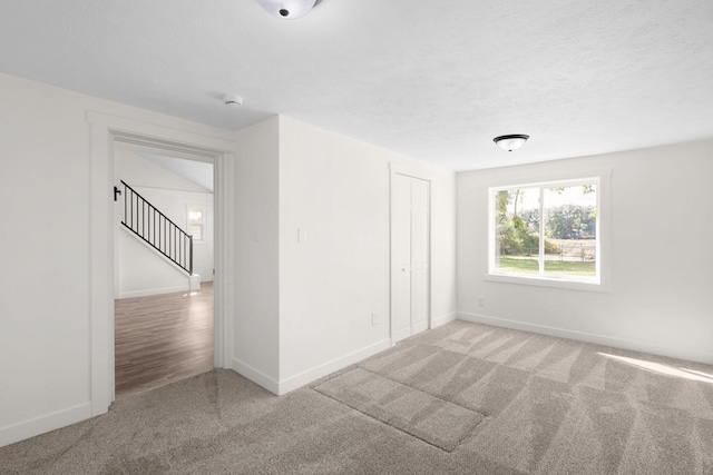 unfurnished room featuring light wood-type flooring and a textured ceiling