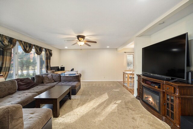 carpeted living room with ceiling fan