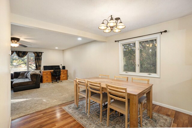 dining area with beam ceiling, hardwood / wood-style floors, and ceiling fan with notable chandelier