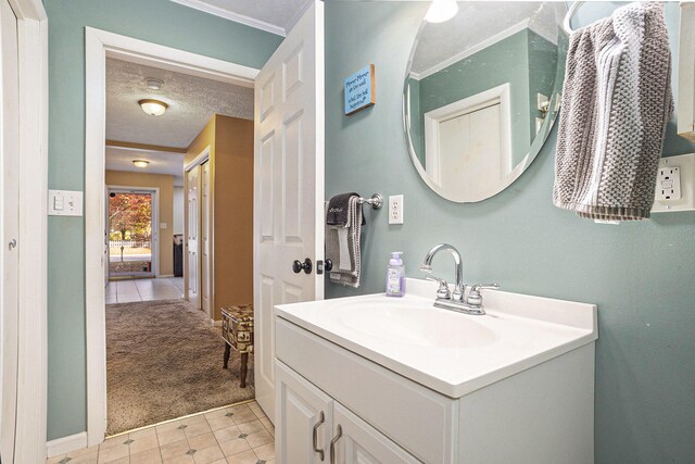 bathroom featuring vanity, crown molding, and a textured ceiling