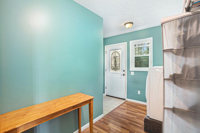 entryway featuring light hardwood / wood-style flooring and a textured ceiling