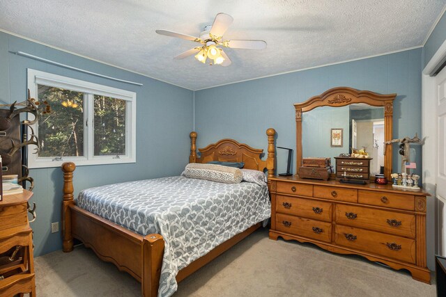 carpeted bedroom with ceiling fan and a textured ceiling