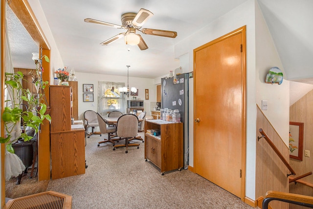 carpeted office with ceiling fan with notable chandelier