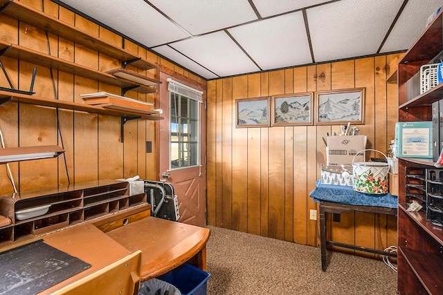 carpeted home office with wooden walls