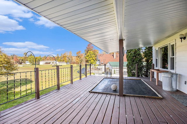 wooden terrace featuring a lawn