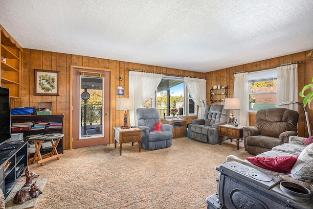 living room with a textured ceiling, a wealth of natural light, and carpet floors