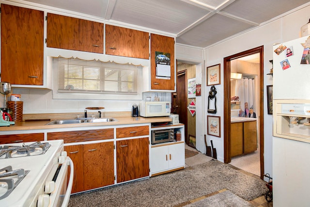 kitchen featuring white appliances, tasteful backsplash, and sink