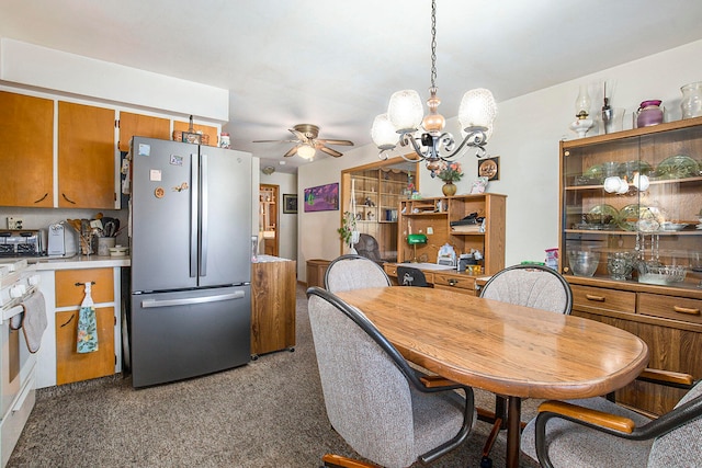 dining room with carpet floors and ceiling fan with notable chandelier