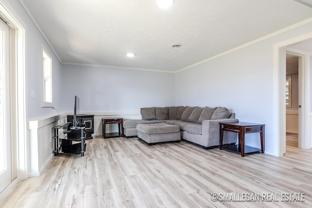 living room with ornamental molding and light hardwood / wood-style flooring