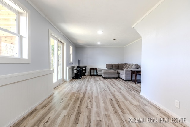 unfurnished living room with light hardwood / wood-style flooring and crown molding