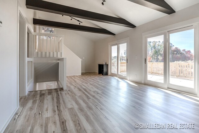 unfurnished living room with lofted ceiling with beams and light hardwood / wood-style flooring