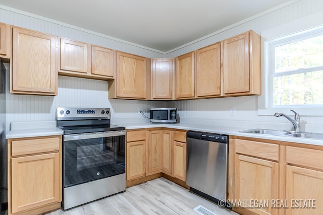 kitchen with ornamental molding, stainless steel appliances, light brown cabinetry, and sink