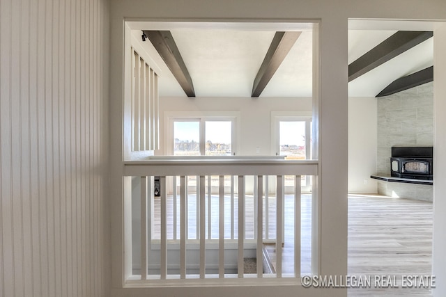 details featuring beamed ceiling, wood-type flooring, and a wood stove