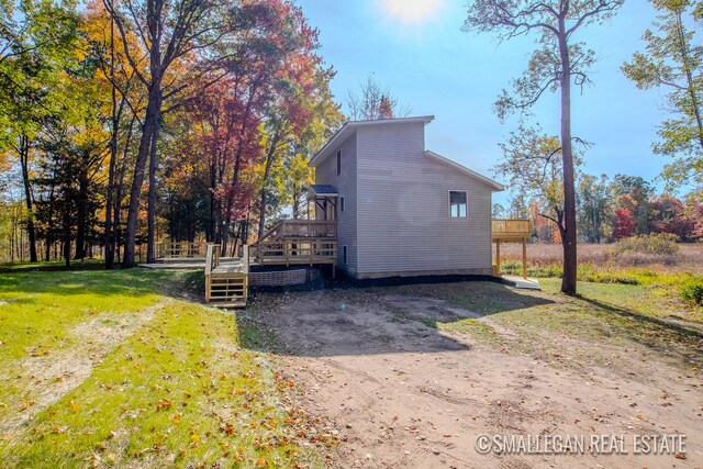 view of property exterior with a deck and a lawn