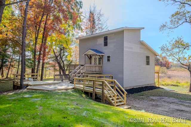 rear view of property with a yard and a deck