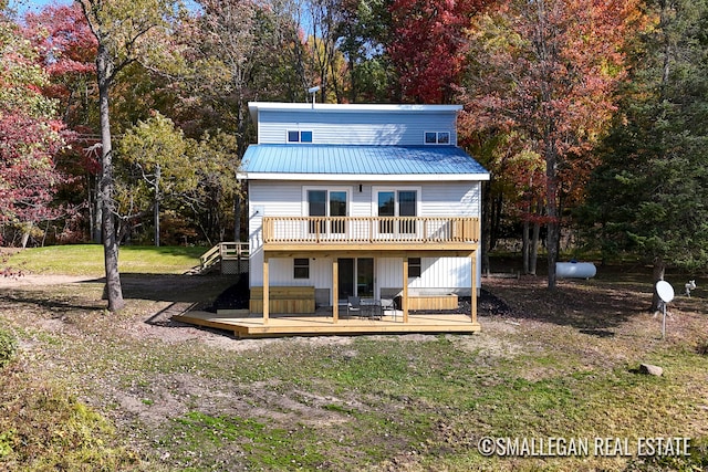 rear view of property with a deck and a lawn