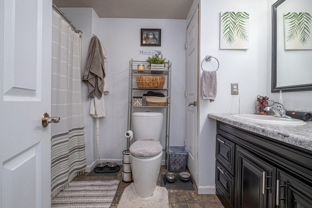 full bathroom featuring vanity, toilet, a textured ceiling, and shower / bath combo with shower curtain